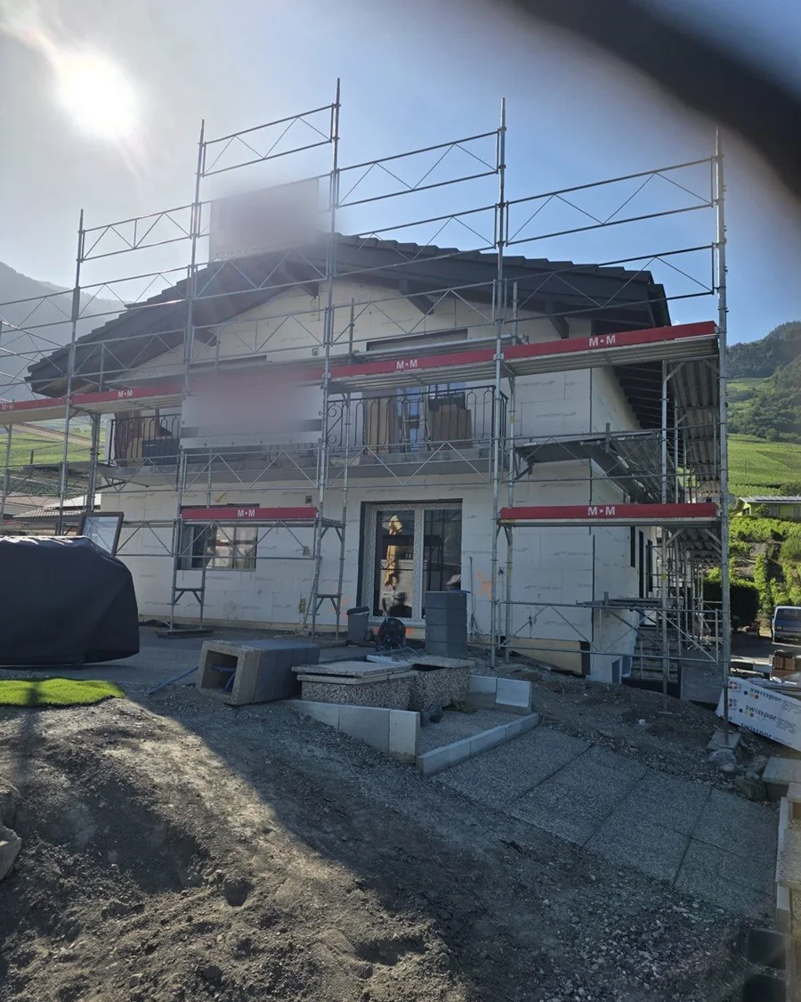 Villa en Valais avant travaux : façade brute et échafaudage monté