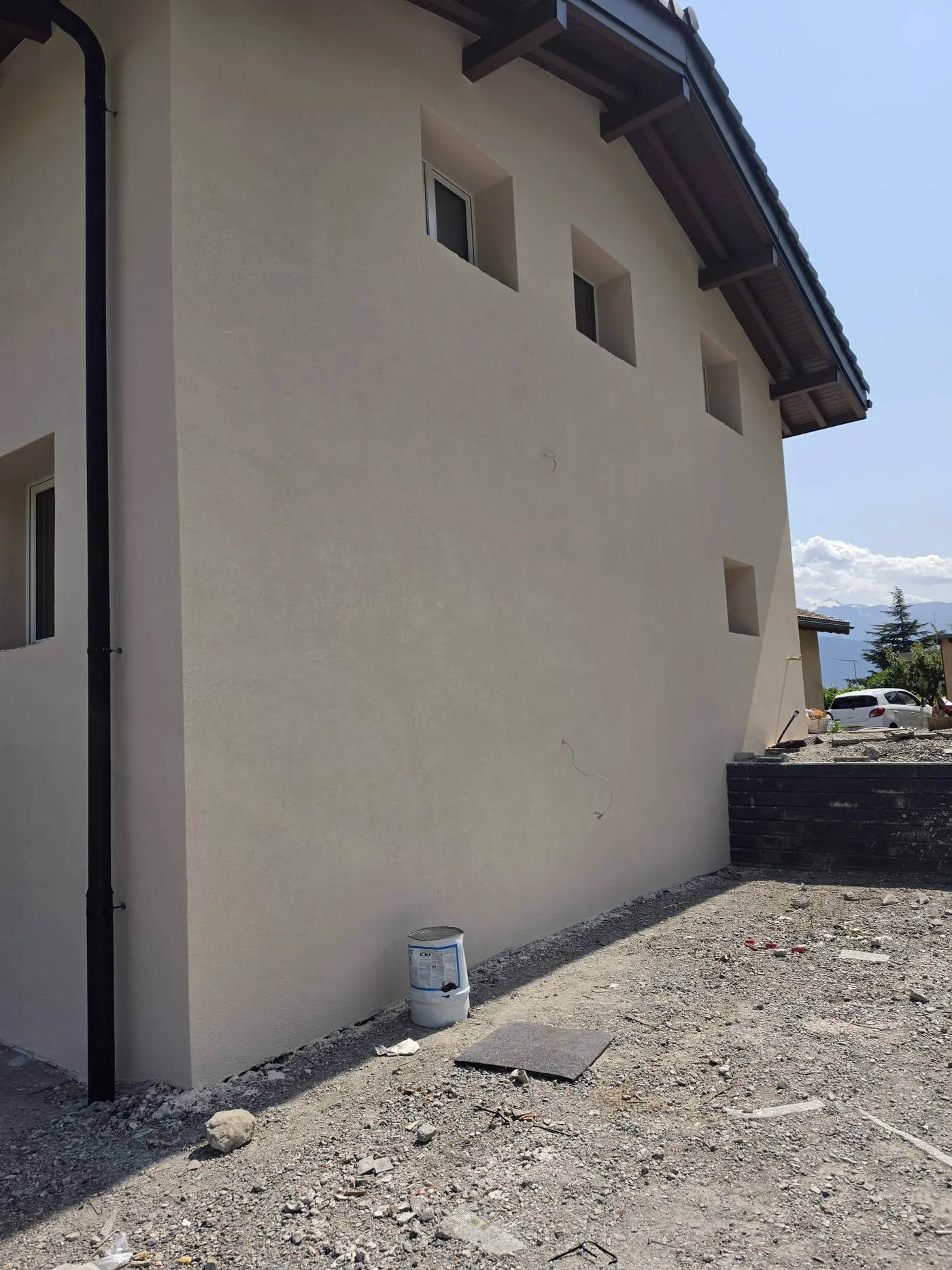 Façade extérieure terminée en crépi clair, chantier ACJ en Valais
